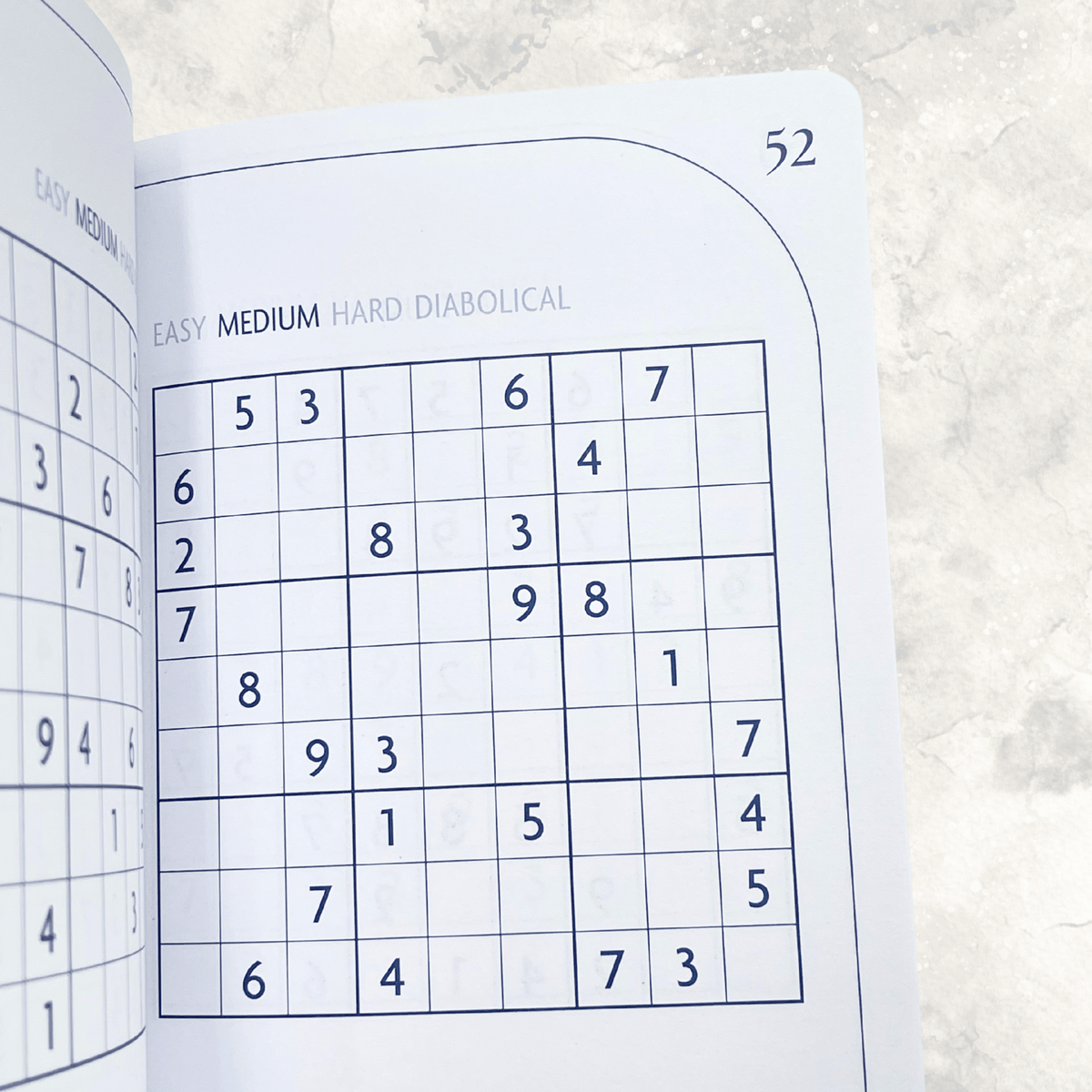 Medium difficulty Sudoku puzzle grids inside the faux suede Sudoku puzzle book