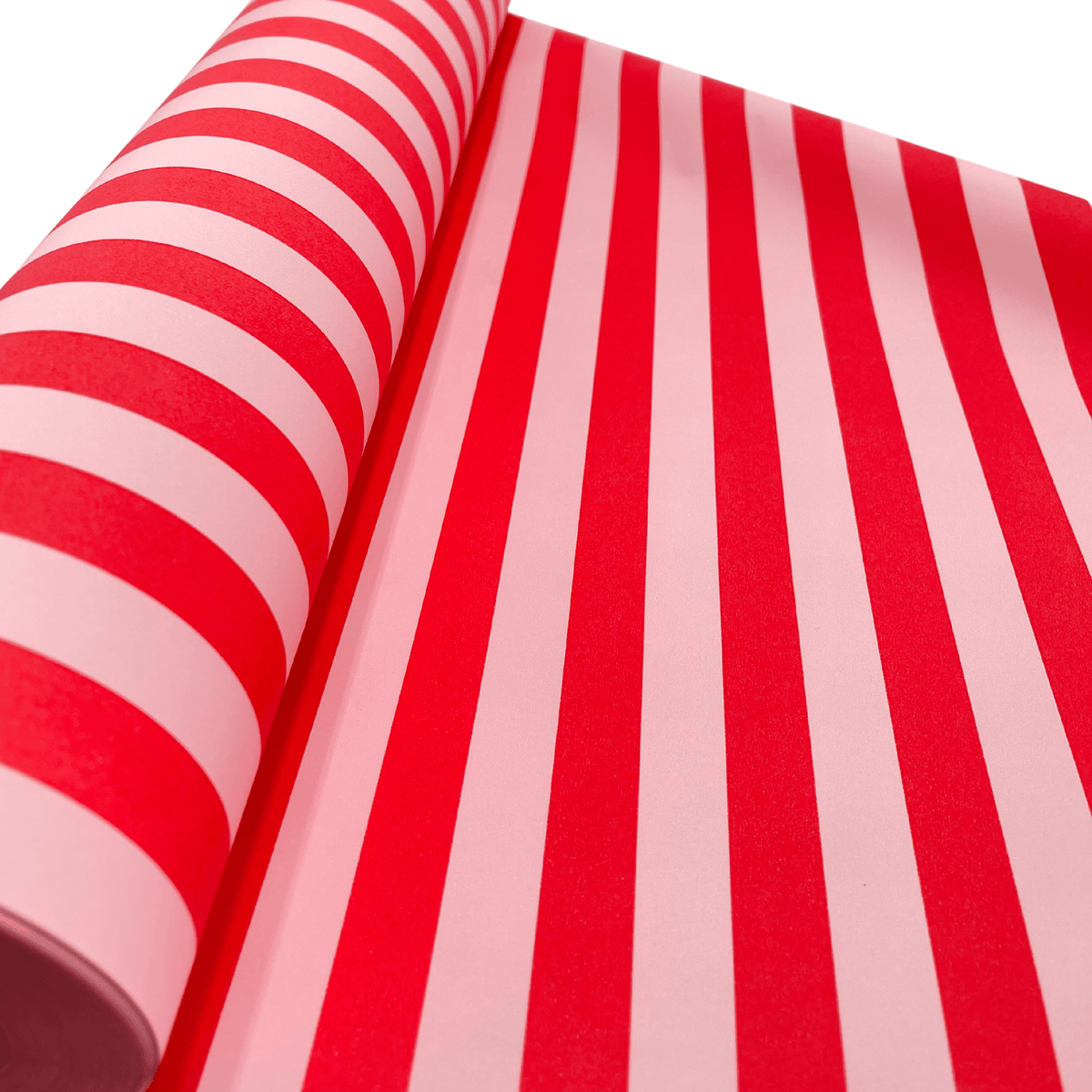 Close-up of Pavilion Poppy red and pink striped Christmas gift wrapping paper showing the bold stripe design and matte finish