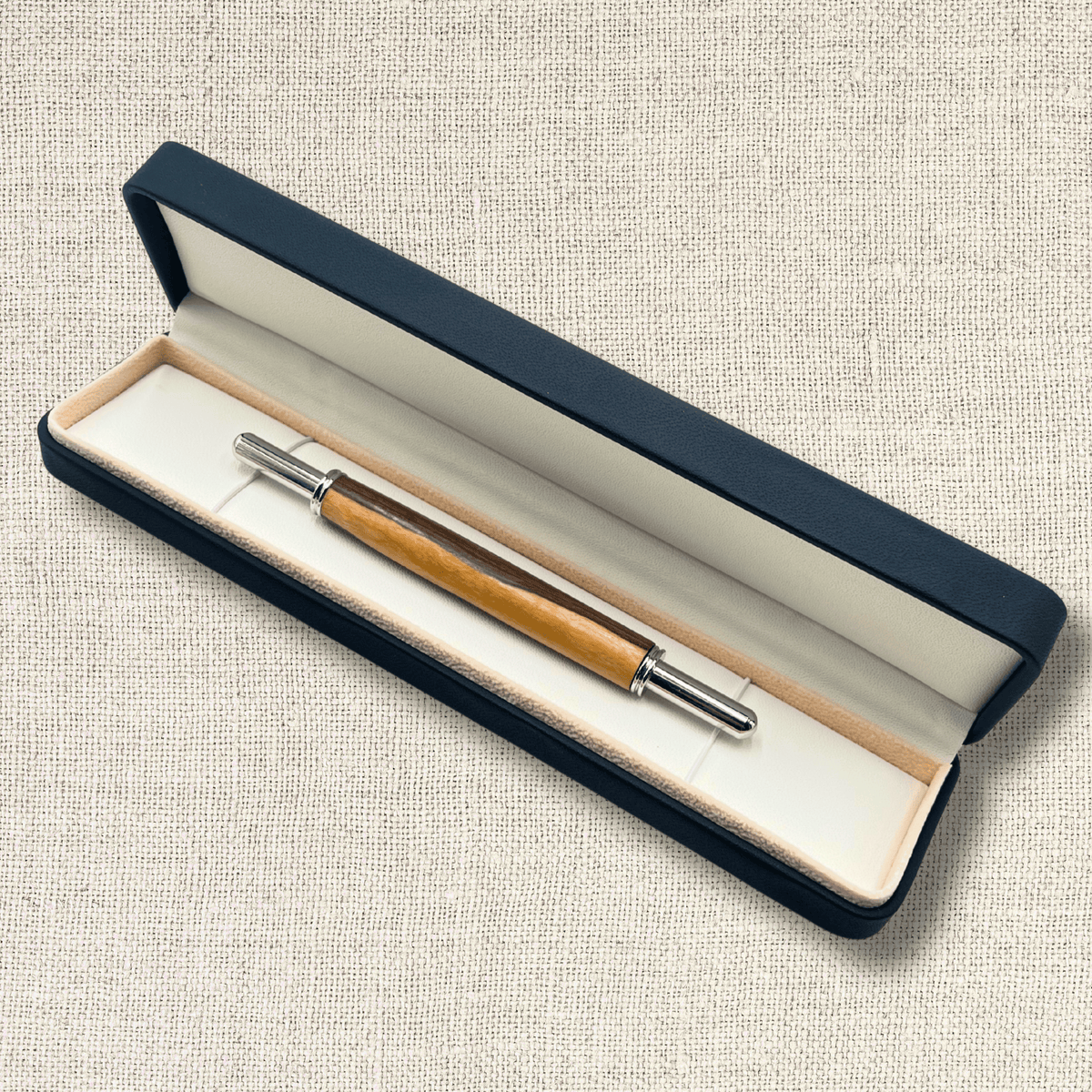 Handmade two-tone wooden seam ripper presented in an open black gift box with light-coloured lining.