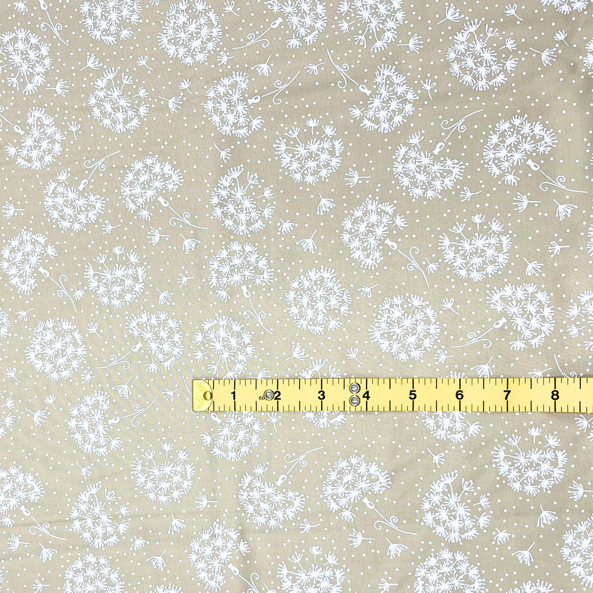 yellow measuring tape showing inches of dandelions