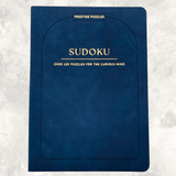 Navy blue faux suede Sudoku puzzle book featuring over 130 puzzles for the curious mind