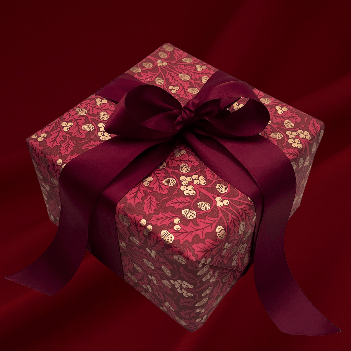 Burgundy botanical Christmas gift wrap styled with matching satin bows