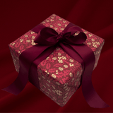Burgundy botanical Christmas gift wrap styled with matching satin bows