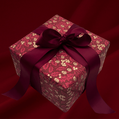 Burgundy botanical Christmas gift wrap styled with matching satin bows