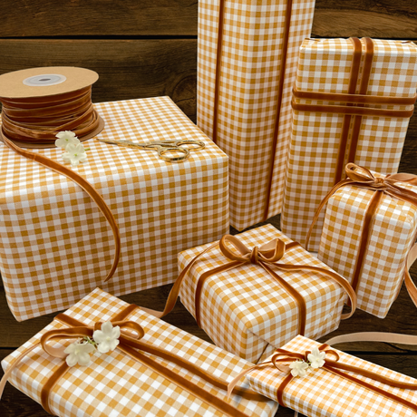 Mustard and white gingham gift wrapping paper with amber velvet ribbon and wrapped gifts