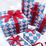 Collection of Christmas presents wrapped in electric blue and pink checkerboard gift paper with coordinating red grosgrain ribbons