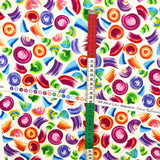 Red, white and green tape measure on selvage of All About Color, multi colour brush strokes on Cream background